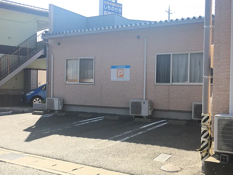 ③医院の裏にある駐車場が右側に見えてきます。